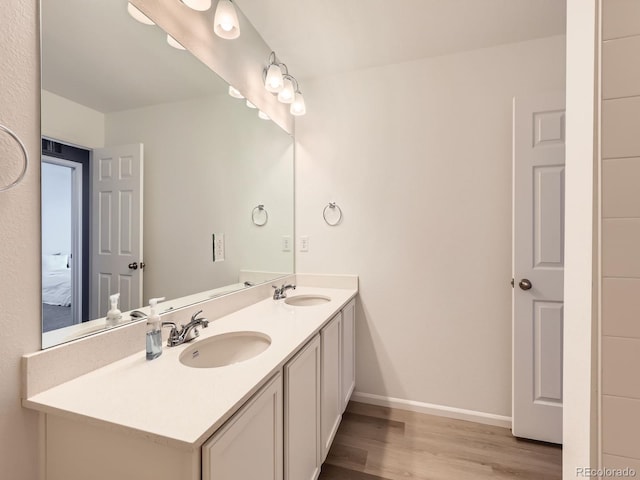 9054 Truckee Ct, Commerce City, CO 80022 - bathroom featuring double vanity, wood finished floors, and connected bathroom
