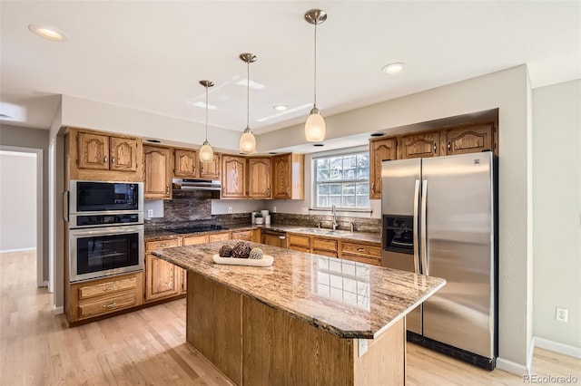 1516 Saltbush Ridge Rd, Highlands Ranch, CO 80126 - kitchen featuring range hood, black appliances, a kitchen island, a sink, and light wood finished floors