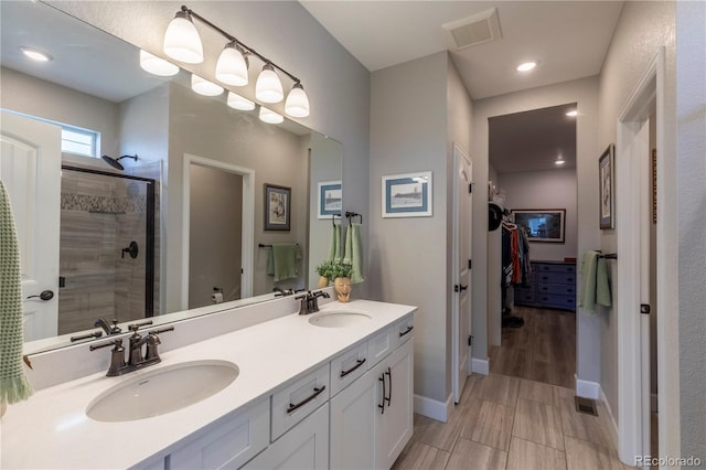 9843 Rosalee Peak St, Littleton, CO 80125 - bathroom featuring a stall shower, baseboards, double vanity, and recessed lighting