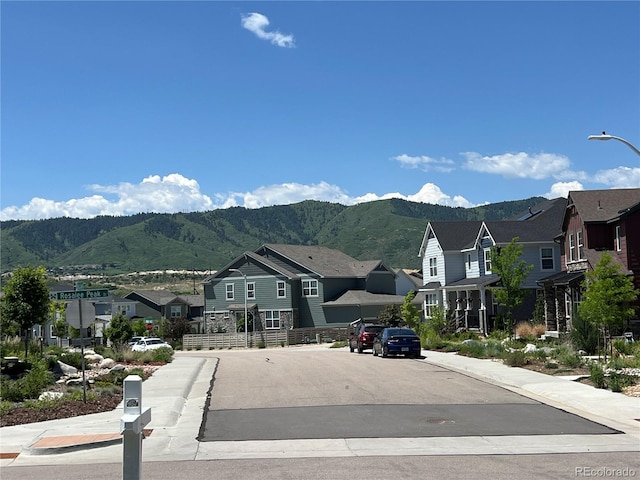 9843 Rosalee Peak St, Littleton, CO 80125 - view of asphalt road with a residential view, a mountain view, sidewalks, street lights, and curbs
