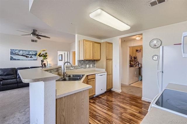 kitchen with kitchen peninsula, tasteful backsplash, white appliances, sink, and light brown cabinets