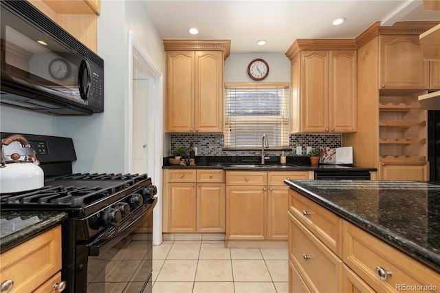 kitchen featuring light tile patterned floors, light brown cabinetry, dark stone counters, black appliances, and sink