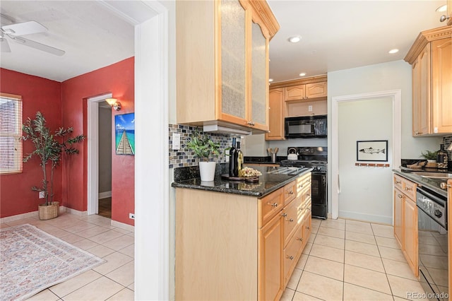 kitchen featuring black appliances, light tile patterned floors, light brown cabinetry, and dark stone countertops