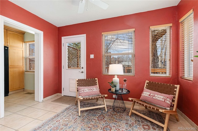 sitting room with ceiling fan and light tile patterned floors