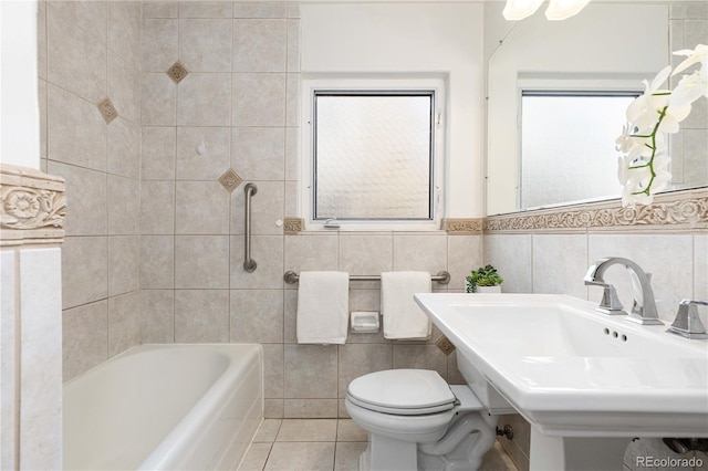 bathroom with toilet, a bathing tub, tile patterned flooring, tile walls, and sink