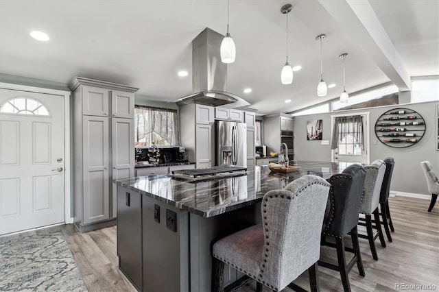 kitchen featuring lofted ceiling with beams, island range hood, gray cabinetry, stainless steel appliances, and a large island