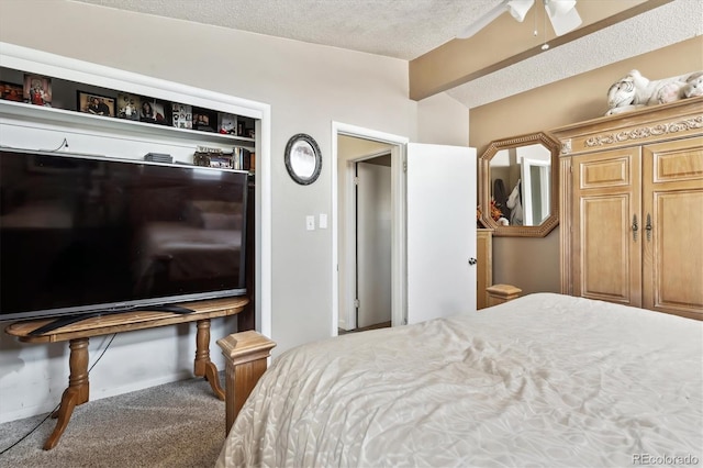 carpeted bedroom featuring beam ceiling and a textured ceiling