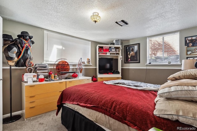 bedroom with light carpet and a textured ceiling