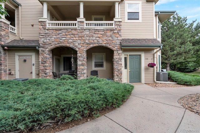 8338 S Independence Cir Unit 108, Littleton, CO 80128 - view of front facade with a balcony, stone siding, and roof with shingles
