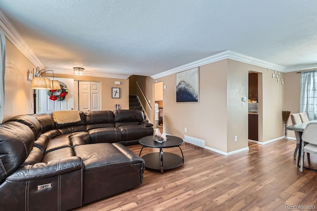 living room with crown molding and light hardwood / wood-style floors