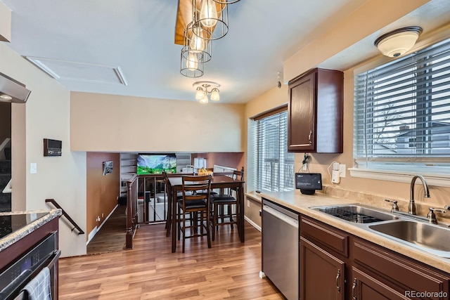 kitchen with dark brown cabinets, pendant lighting, sink, light hardwood / wood-style floors, and black appliances