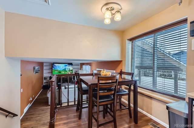 dining area featuring dark hardwood / wood-style floors and a chandelier