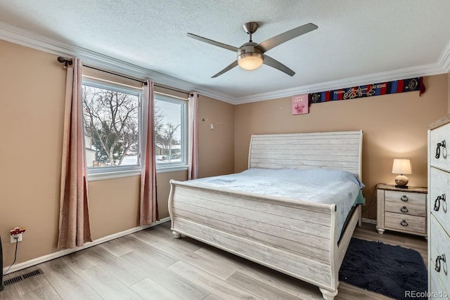 bedroom featuring ceiling fan, light hardwood / wood-style flooring, ornamental molding, and a textured ceiling