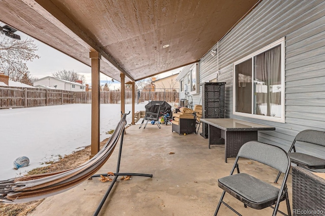 snow covered patio featuring a grill