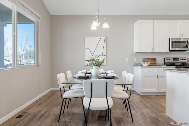 dining room featuring visible vents, baseboards, an inviting chandelier, and wood finished floors