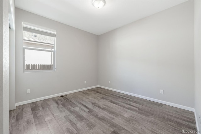 empty room featuring baseboards and wood finished floors