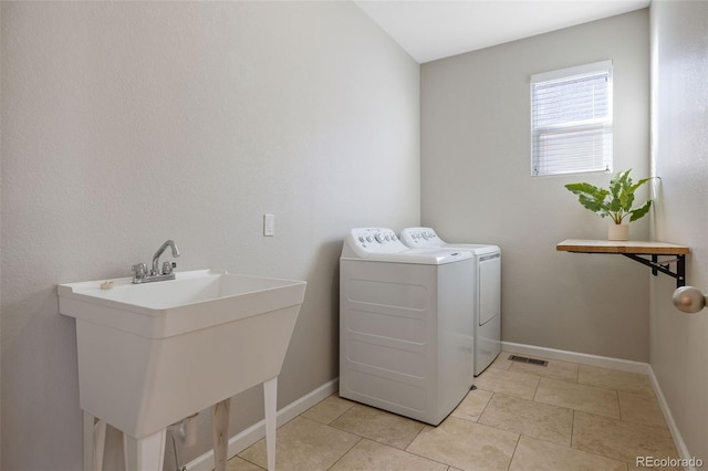 laundry room with a sink, separate washer and dryer, light tile patterned floors, baseboards, and laundry area