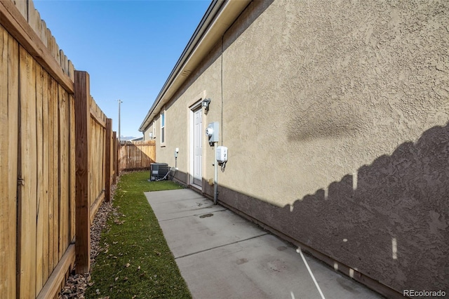 view of home's exterior with a patio, cooling unit, a fenced backyard, and stucco siding