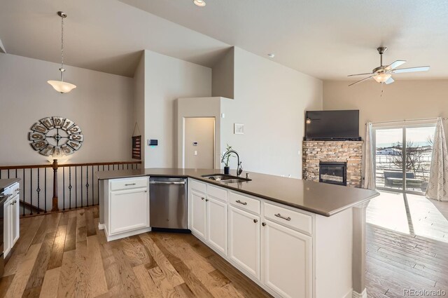 kitchen with stainless steel dishwasher, sink, pendant lighting, light hardwood / wood-style flooring, and white cabinets