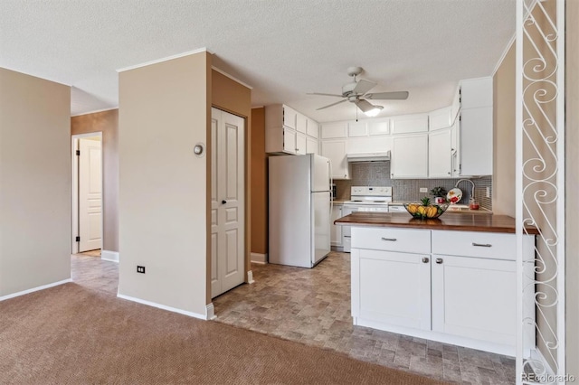 kitchen featuring white cabinetry, wooden counters, backsplash, light colored carpet, and white appliances