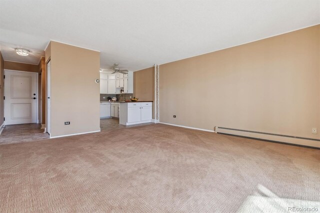 690 S Alton Way Unit 1C, Denver, CO 80247 - unfurnished living room with light colored carpet, a baseboard radiator, baseboards, and a ceiling fan