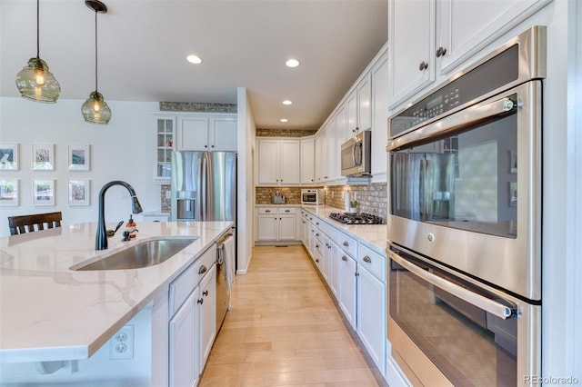 15389 W 50th Dr, Golden, CO 80403 - kitchen with a sink, stainless steel appliances, white cabinetry, hanging light fixtures, and recessed lighting