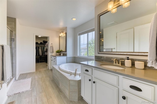 15389 W 50th Dr, Golden, CO 80403 - bathroom with a shower stall, a garden tub, vanity, and wood finished floors