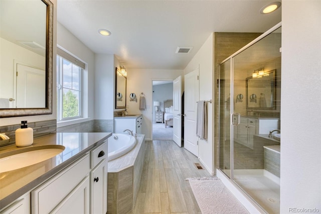 15389 W 50th Dr, Golden, CO 80403 - bathroom with a shower stall, two vanities, recessed lighting, a garden tub, and wood finished floors