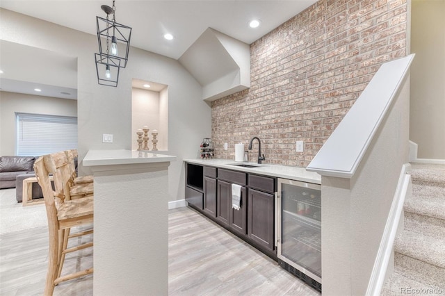 15389 W 50th Dr, Golden, CO 80403 - indoor wet bar with beverage cooler, light wood-type flooring, decorative light fixtures, baseboards, and stairway