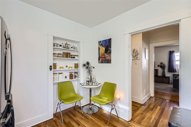 sitting room with dark hardwood / wood-style floors and built in features