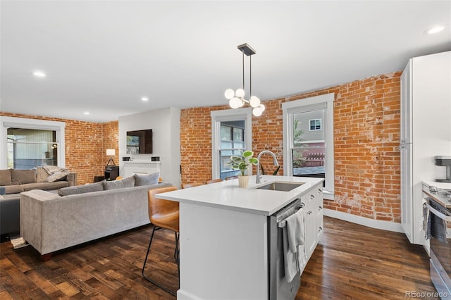 kitchen featuring appliances with stainless steel finishes, sink, a center island with sink, and white cabinets