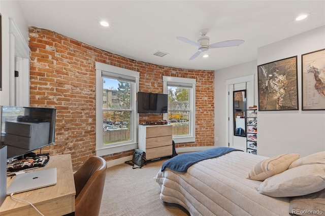 carpeted bedroom with brick wall and ceiling fan