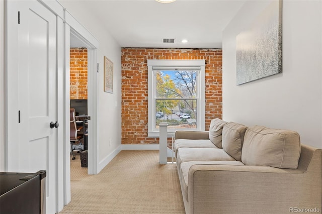 living room with light colored carpet and brick wall