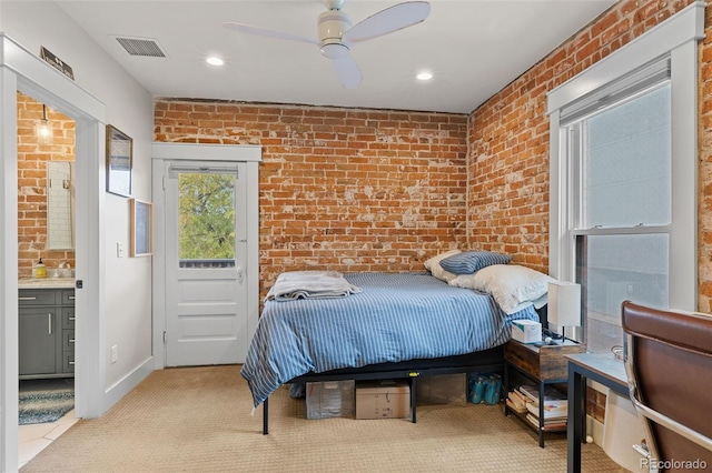 bedroom with brick wall, ceiling fan, and ensuite bath