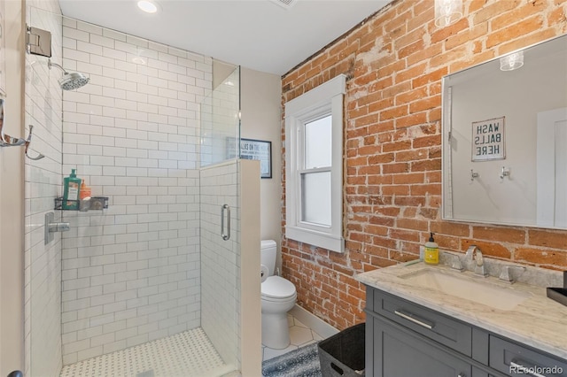 bathroom with vanity, a shower with door, toilet, and brick wall