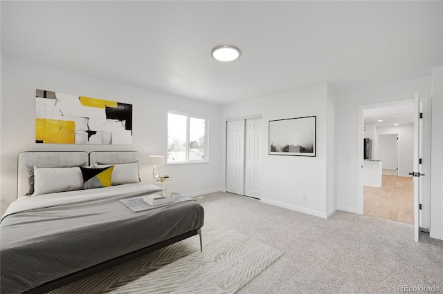 carpeted bedroom with a closet and baseboards