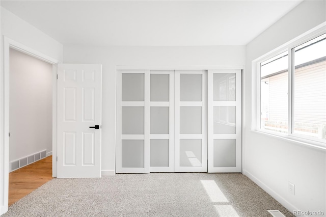 unfurnished bedroom featuring carpet floors, visible vents, and baseboards