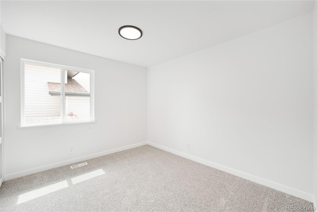 carpeted empty room with visible vents and baseboards