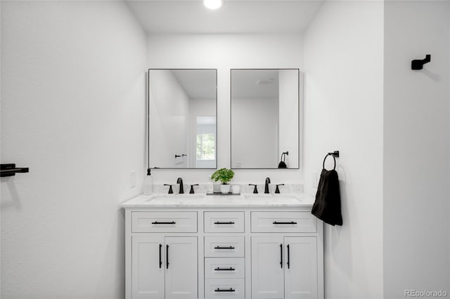 full bath with a sink and double vanity