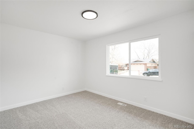 empty room featuring visible vents, carpet flooring, and baseboards