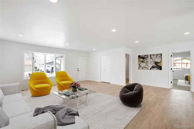 living room featuring baseboards, light wood finished floors, and recessed lighting
