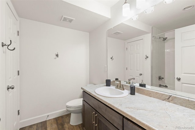 full bathroom with baseboards, wood finished floors, toilet, and vanity
