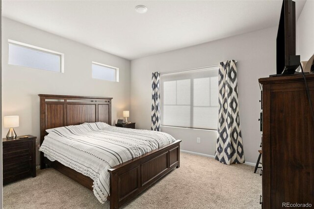bedroom featuring light carpet and baseboards