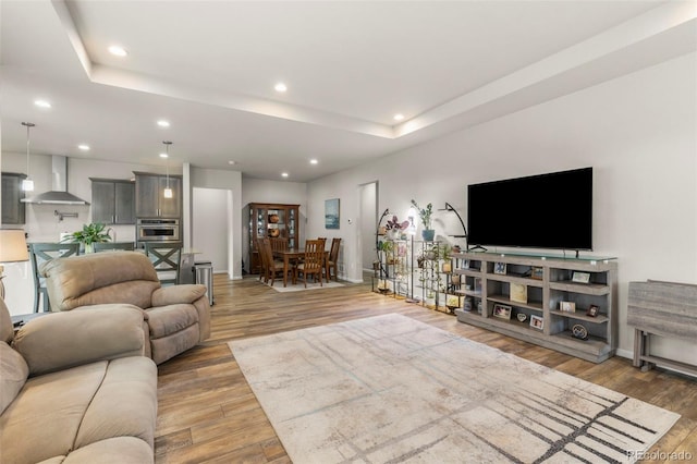 living area with recessed lighting, light wood-style floors, and baseboards