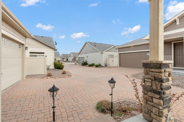6712 Golden Briar Ln, Colorado Springs, CO 80927 - garage featuring decorative driveway and a residential view