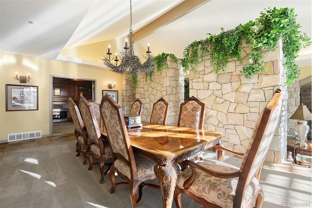 dining space with beam ceiling and an inviting chandelier