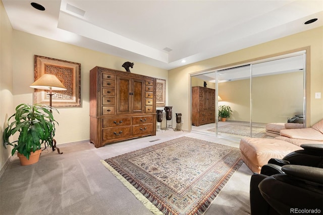 living room featuring light carpet and a tray ceiling