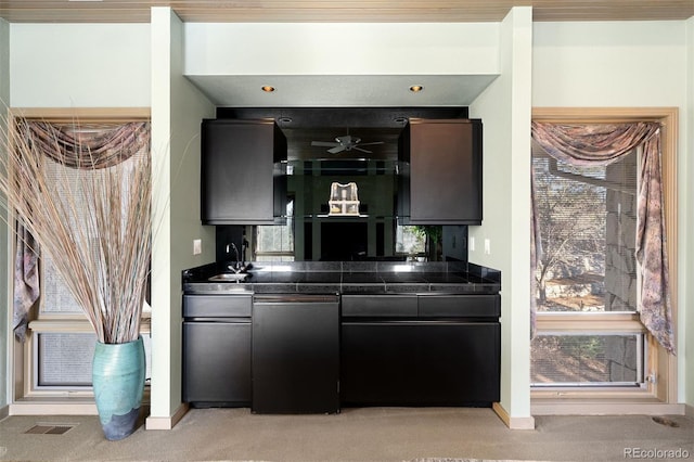 bar featuring baseboards, visible vents, a sink, and light colored carpet