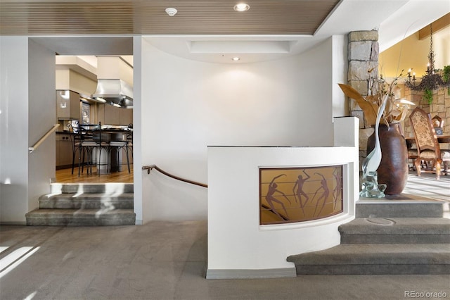 staircase featuring a tray ceiling, carpet flooring, and recessed lighting