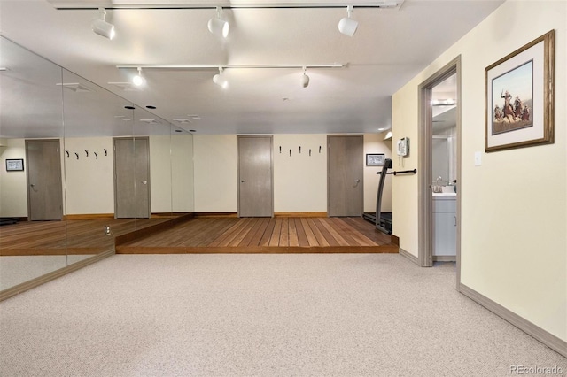 interior space featuring baseboards and track lighting